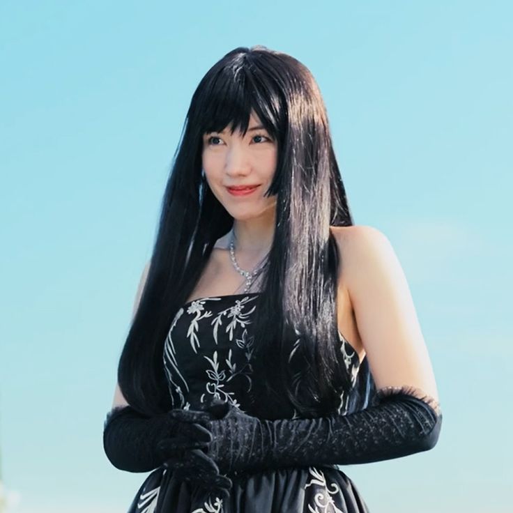 a woman with long black hair wearing gloves