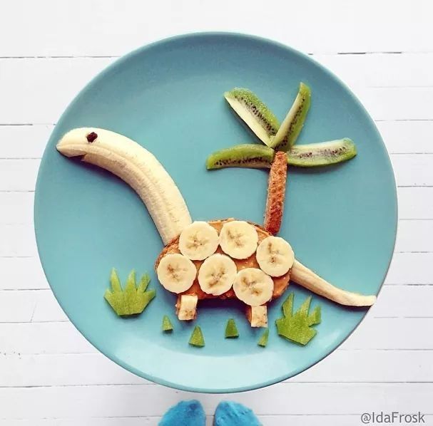 a plate with bananas, banana slices and a dinosaur on it