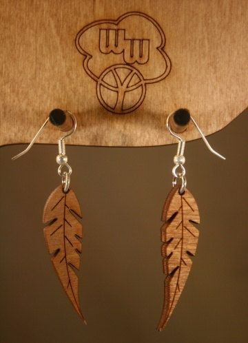 the earrings are made from wood and have leaves attached to them with black beaded earwires