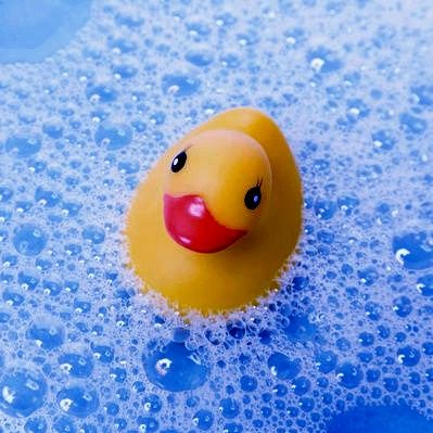 a yellow rubber ducky floating in blue water