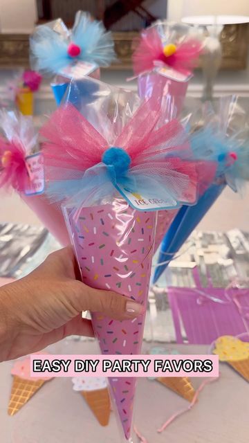 a hand holding a pink cone with blue and pink decorations