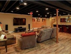 a living room with couches and chairs in it's center area is lit by recessed lighting