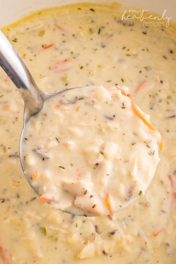 a ladle full of creamy soup with carrots and celery