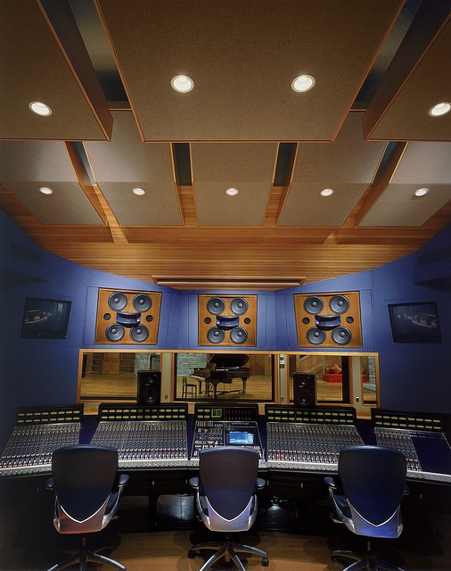 an empty recording studio with multiple monitors and sound equipment