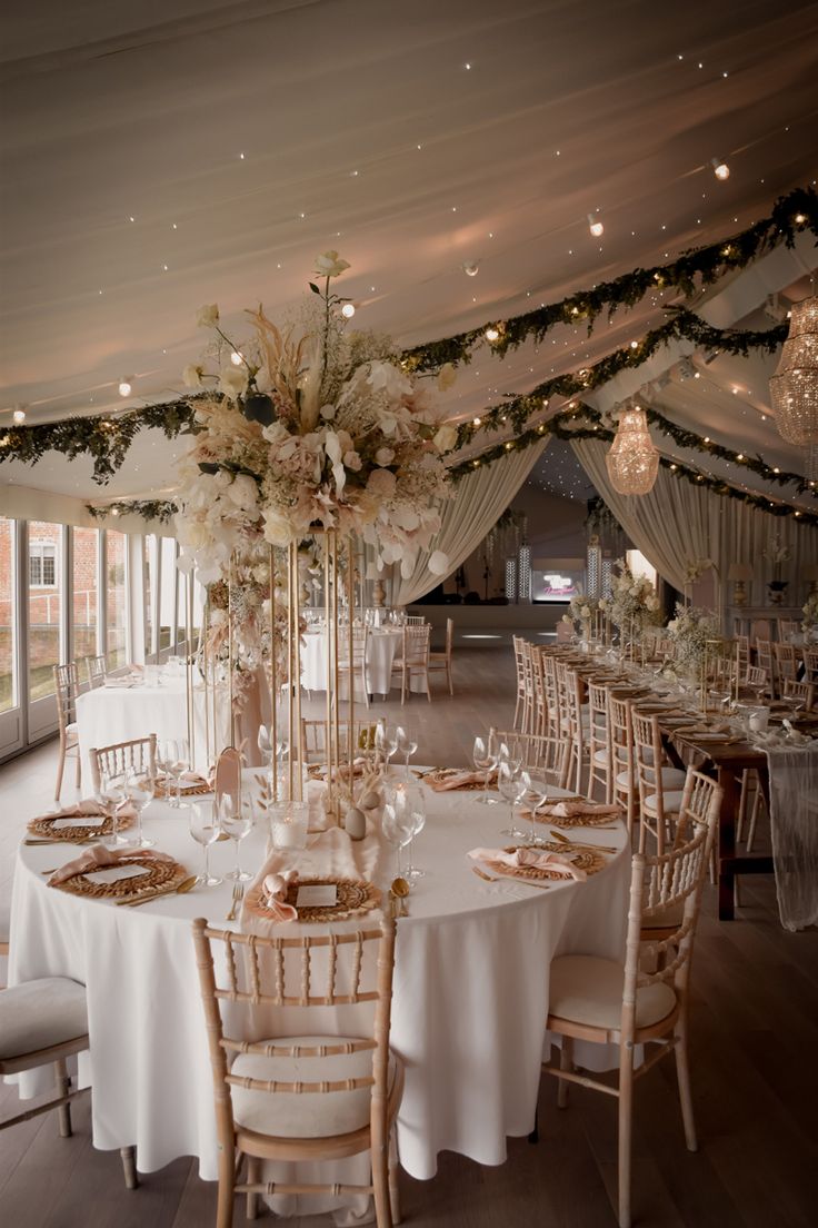 a banquet hall with tables, chairs and chandeliers set up for a formal function