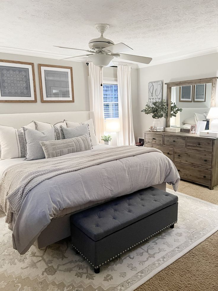 a bedroom with a large bed, dresser and mirror in it's center area