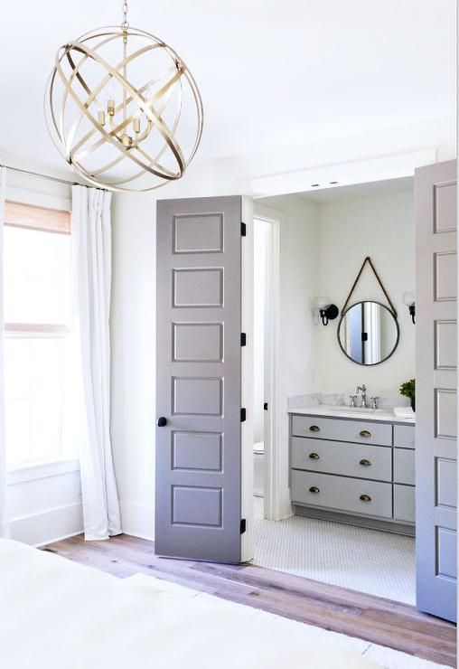 an open door leading to a bathroom with a chandelier hanging from the ceiling