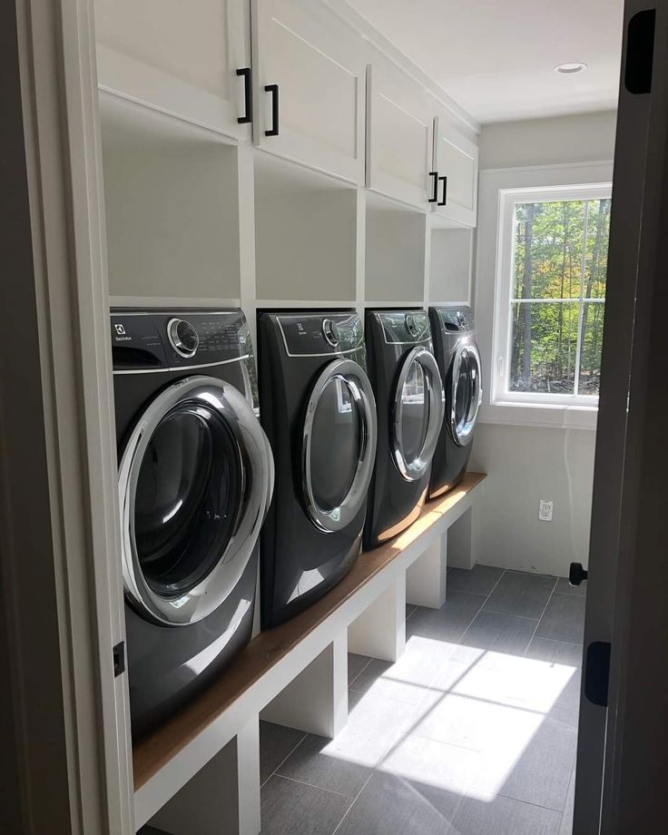 a row of washers sitting next to each other in front of a dryer