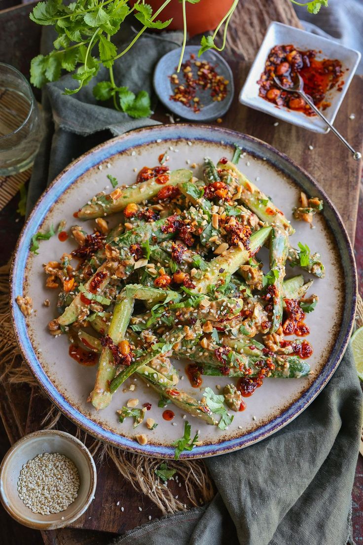 a white plate topped with asparagus covered in seasoning next to other dishes