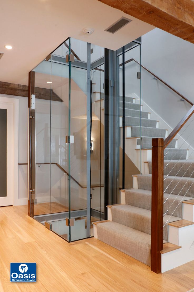 an empty room with stairs and glass doors on the walls, in front of a wooden floor