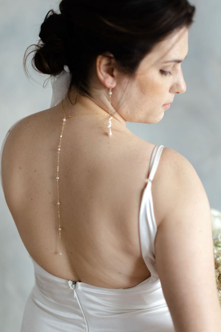 If you're looking for a statement for your big day, look no further. Our Pearl Back Drop Necklace features a 5" front drop and a 7" back drop, adorned with hand fastened freshwater pearls to finish the look. This piece is classic, elegant, and sure to make you like the beautiful bride you are on your special day. Includes 10 freshwater pearls + 16" neck length of 14k gold-filled cable cha Gold Pearl Chain Backdrop Necklace For Wedding, Pearl Bridal Necklace For Wedding, Adjustable Single Strand Pearl Necklace For Wedding, Gold Backdrop Necklace With Pearl Chain For Wedding, Graceful Pearl Chain Jewelry For Wedding, Graceful Pearl White Pearl Necklace For Wedding, Formal Backdrop Necklace With Pearl Pendant, Delicate Long Drop Backdrop Necklace For Formal Occasions, Delicate Long Drop Backdrop Necklace For Formal Events