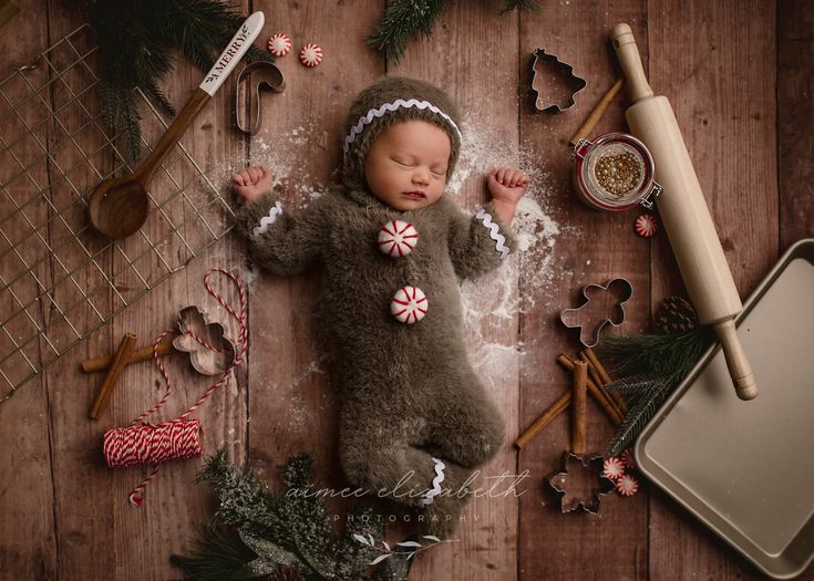 a baby is laying on the floor next to christmas decorations and baking utensils