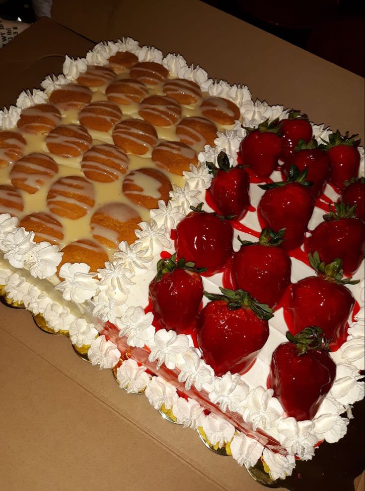 two large cakes with strawberries on top and white frosting