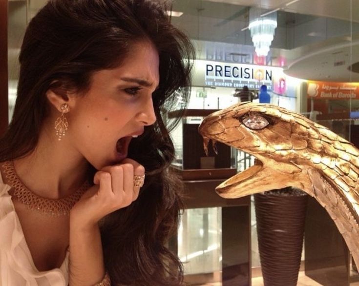 a woman looking at a fake snake head