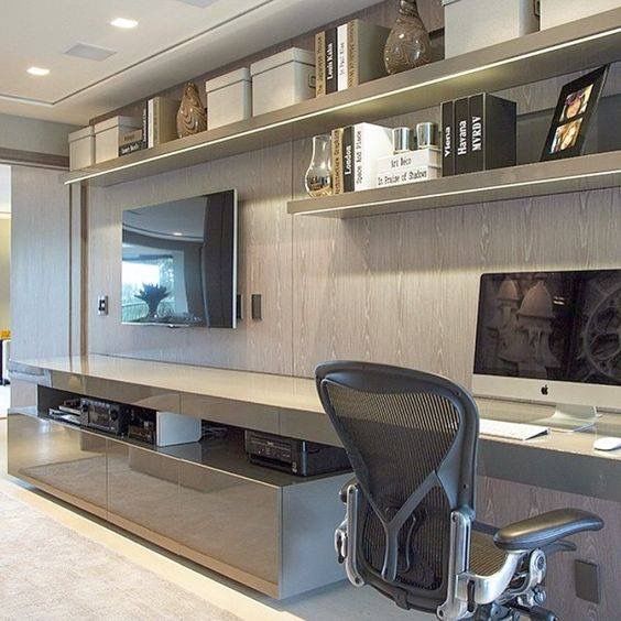 an office with a desk, computer monitor and chair in front of the wall mounted flat screen tv