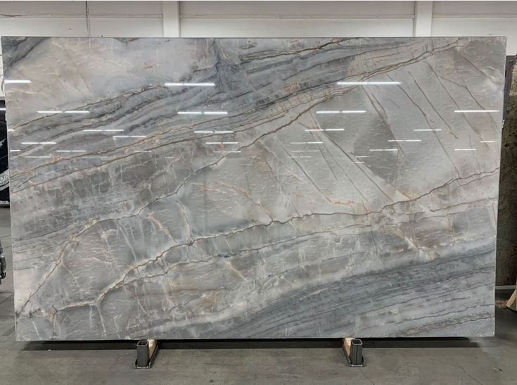 a large marble slab is on display in a storeroom, with several other items behind it