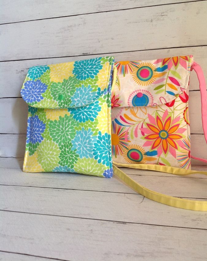 two purses sitting next to each other on top of a white wooden floor and one has a pink strap