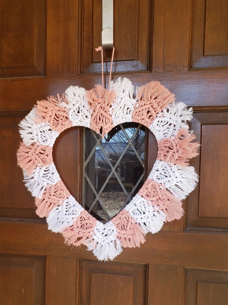 a heart shaped wreath hanging on the front door