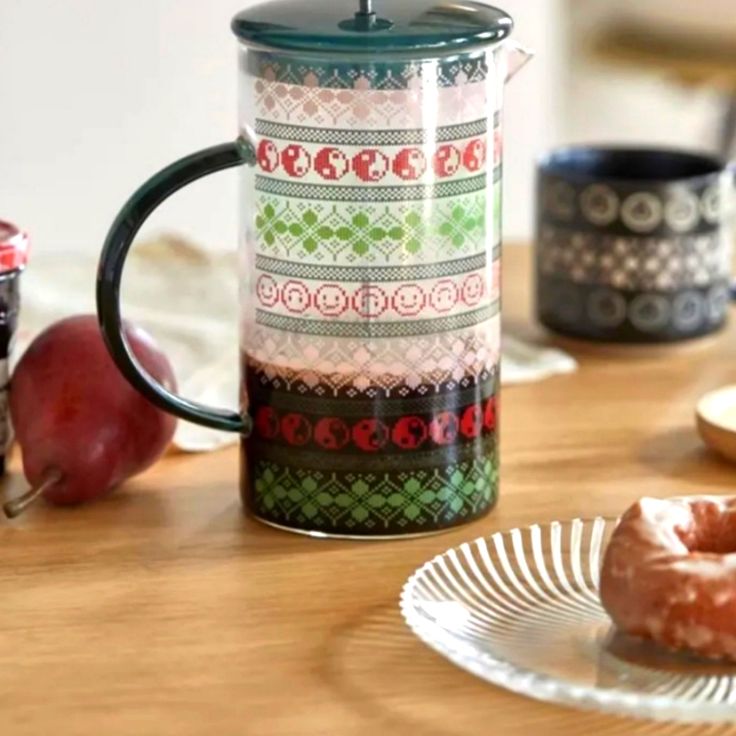 two donuts are sitting on a plate next to a coffee mug