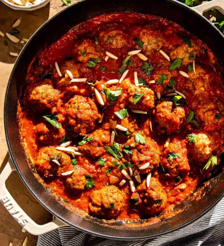 meatballs with tomato sauce and parsley in a pan