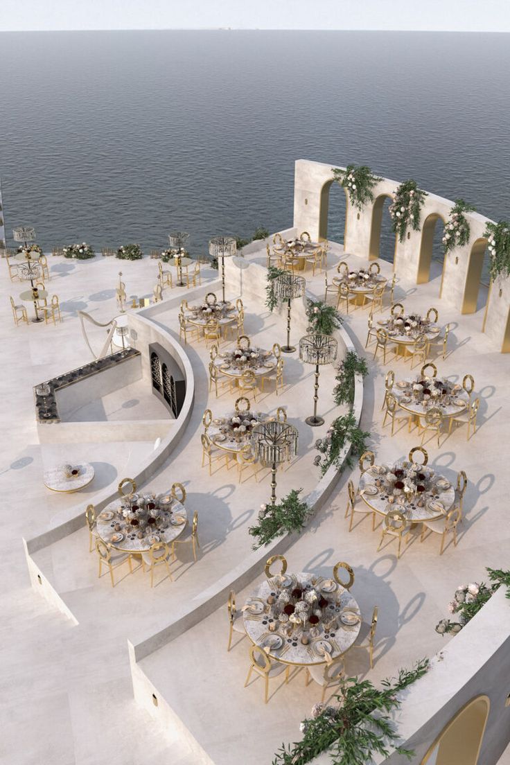 an aerial view of a dining area with tables and chairs near the water's edge