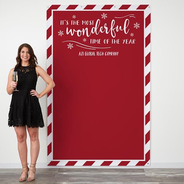 a woman standing in front of a red and white sign that says it's the most wonderful time of the year