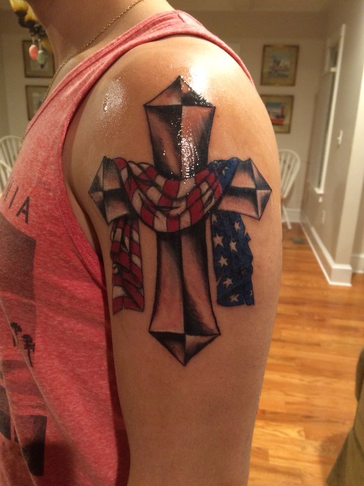 a man with a cross tattoo on his arm and an american flag in the background