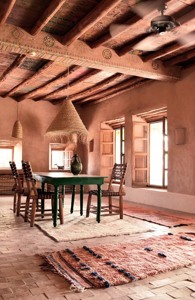 a dining table and chairs in a room with wooden beams on the ceiling above it