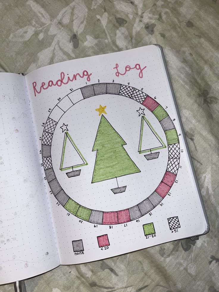 an open notebook with a christmas tree drawn on the page and writing reading to go