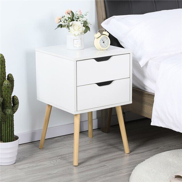 a white nightstand with two drawers next to a cactus