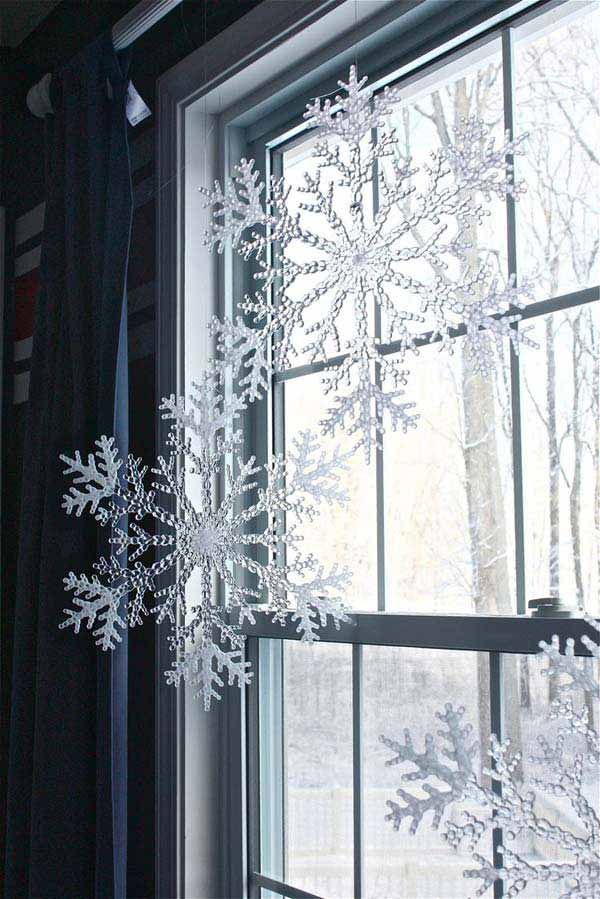 snow flakes are hanging from the window sill