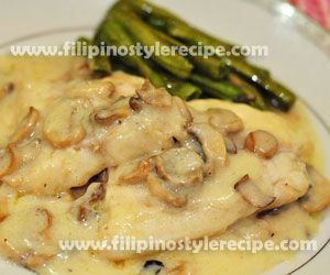 a white plate topped with meat covered in gravy and asparagus