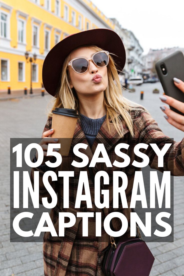 a woman in a hat and sunglasses taking a selfie with her cell phone while standing on the street