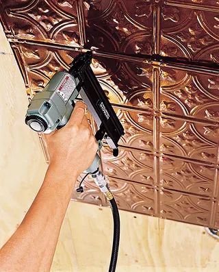 a person using a power drill to fix a tin ceiling