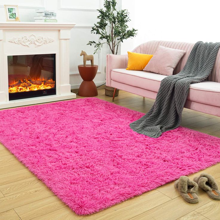 a living room with a pink rug and fireplace