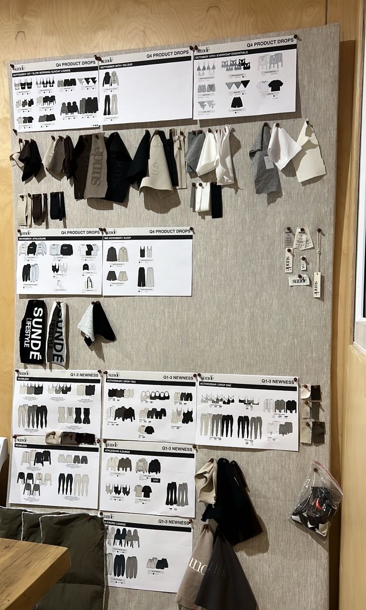 there is a wall display with clothes hanging on it and paper clips attached to the wall