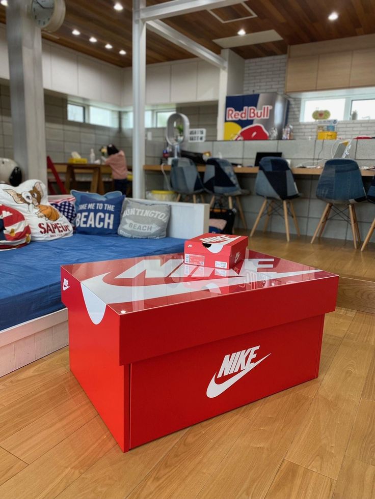 a red box sitting on top of a hard wood floor next to a blue bed