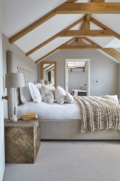 a large bed sitting under a wooden beam in a bedroom