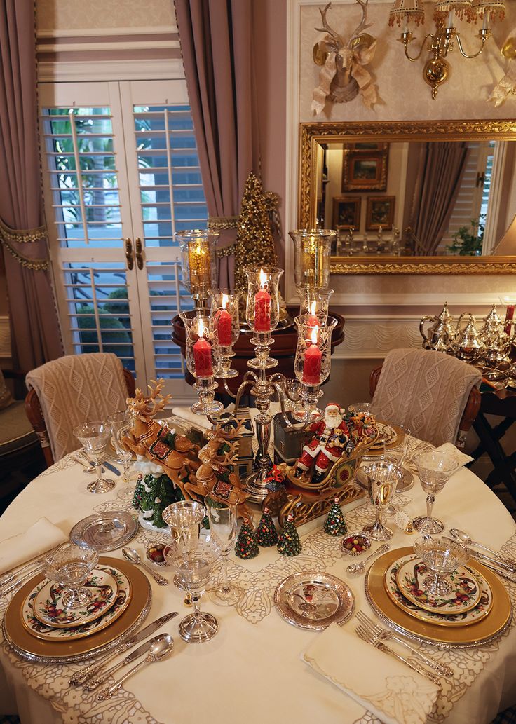 a dining room table is set for christmas dinner with candles and dishes on it,