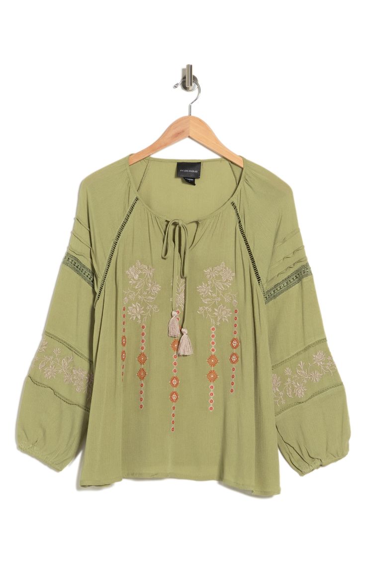 A beautifully embroidered tunic top features a keyhole tie neck and balloon sleeves for boho-chic style. 26" length (size M) Split neck with tassel ties Long raglan balloon sleeves with elastic cuffs Front keyhole Embroidered Inset ladder and lace trim Textured woven construction 100% rayon Hand wash, line dry Imported Model stats: 5'10" height, 32" bust, 25" waist, 36" hip. Model is wearing size M. Bohemian Long Sleeve Embroidered Top For Vacation, Spring Embroidered Rayon Blouse, Bohemian Long Sleeve Peasant Top With Embroidered Neckline, Spring Bohemian Peasant Top With Blouson Sleeves, Bohemian Embroidered Peasant Top For Fall, Spring Peasant Top With Embroidered Sleeves, Bohemian Peasant Top With Embroidered Neckline For Spring, Flowy Bohemian Blouse With Embroidery, Spring Bohemian Embroidered Tunic Top