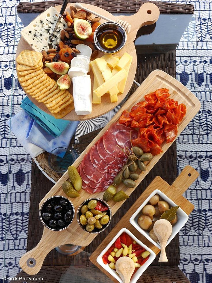 an assortment of food is displayed on a serving platter with cheese, crackers and olives