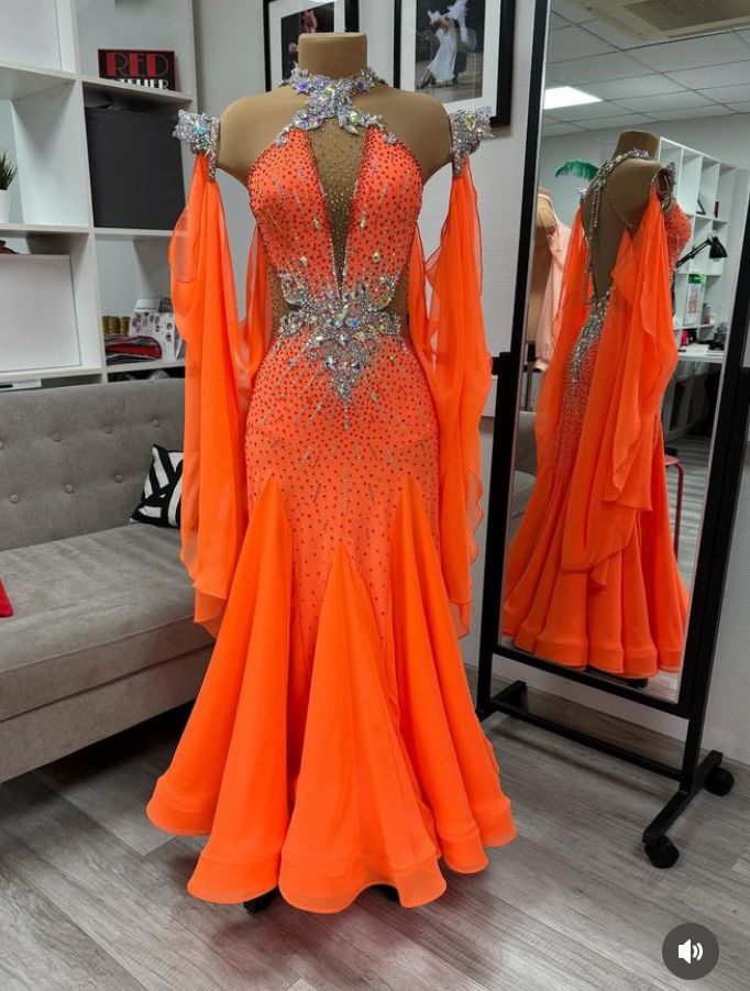 an orange dress is on display in front of a mirror with other mannequins