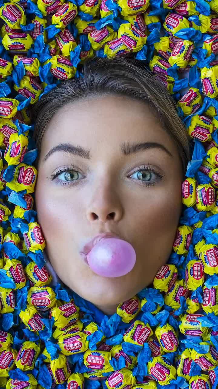 a woman sticking her tongue out in the middle of candy candies, as if it were chewing gum