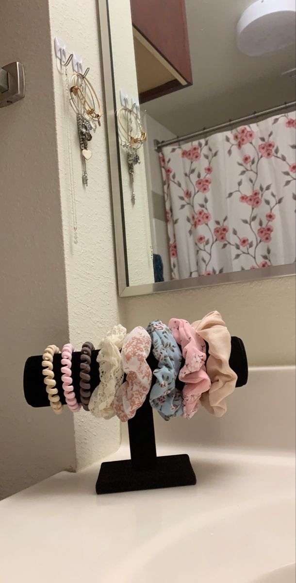 a bunch of hair ties sitting on top of a stand in front of a mirror