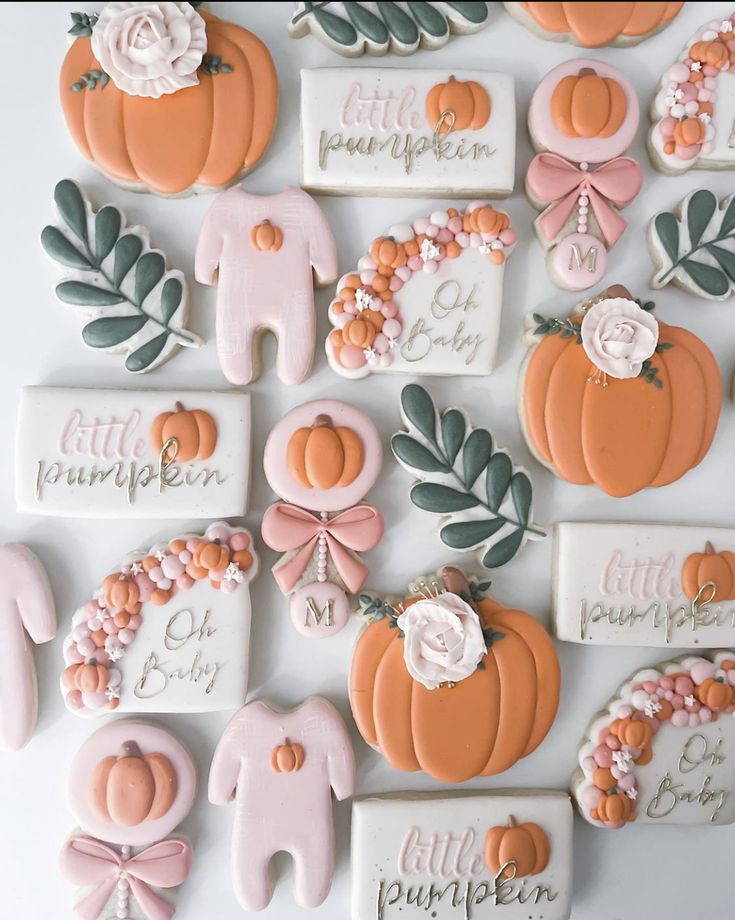 decorated cookies are arranged in the shape of pumpkins and baby's first names