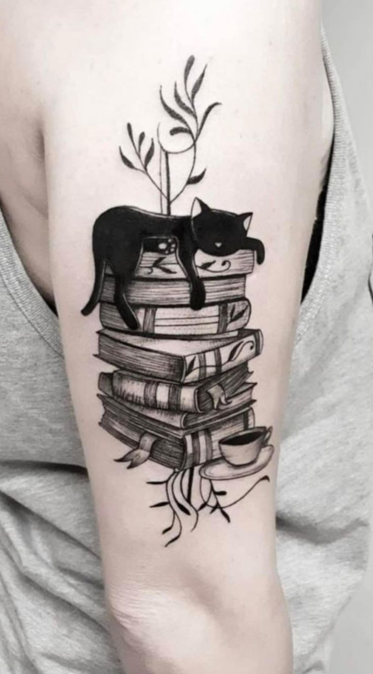 a black cat sitting on top of a stack of books