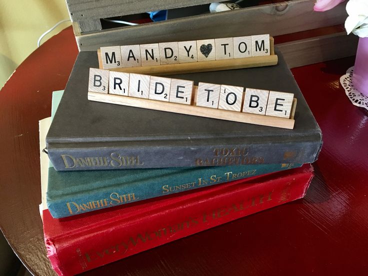 a stack of books with scrabble blocks spelling out the names of bride to be