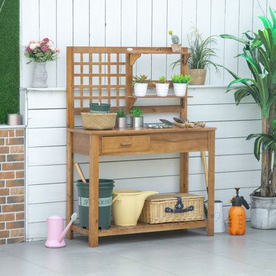 a potted plant sitting on top of a wooden table next to a brick wall