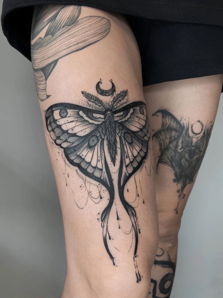 a woman's legs with tattoos on them and a butterfly in the middle of her leg