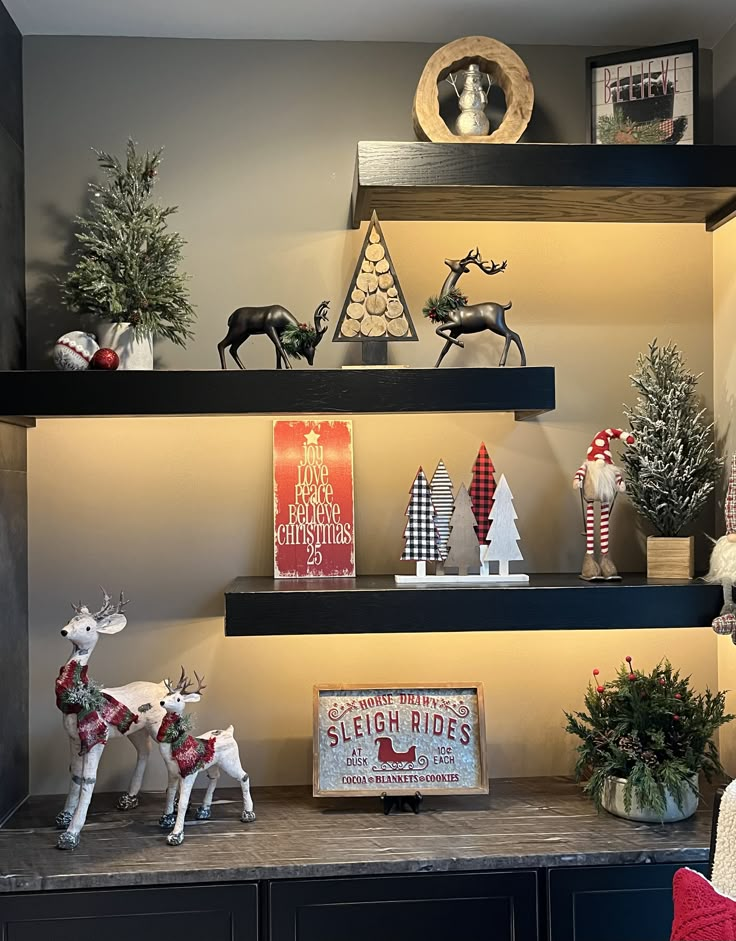 christmas decorations are displayed on shelves in the living room